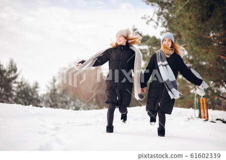 Two cute girls in a winter park Two cute girls in a winter park 61602339
