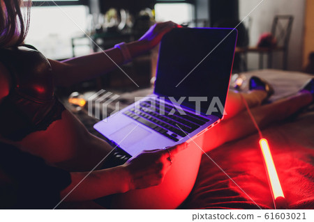 Beautiful, young girl posing in front of a web camera, working as a model. The concept of online flirting. Beautiful, young girl posing in front of a web camera, working as a model. The concept of online flirting. 61603021