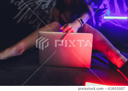 Beautiful, young girl posing in front of a web camera, working as a model. The concept of online flirting. 61603087