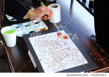 Malaysian draw batik or batik canting. The color control by wet wax that drawn earlier. Malaysian draw batik or batik canting. The color control by wet wax that drawn earlier. 61604001