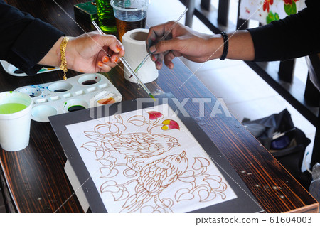 Malaysian draw batik or batik canting. The color control by wet wax that drawn earlier. Malaysian draw batik or batik canting. The color control by wet wax that drawn earlier. 61604003