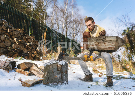 Man chopping wood with an axe, pieces and debris flying around Man chopping wood with an axe, pieces and debris flying around 61606586