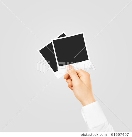 Hand holding blank photo frames mockup. Empty old photography te 61607407