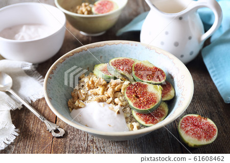 Oatmeal, yogurt, ripe figs, walnuts in bowl and milk Oatmeal, yogurt, ripe figs, walnuts in bowl and milk 61608462
