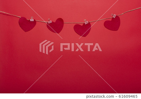 Decorative clothespins with hearts on a rope on a red background for Valentine's Day, wedding, birthday and other holidays, view from the top. Decorative clothespins with hearts on a rope on a red background for Valentine's Day, wedding, birthday and other holidays, view from the top. 61609465