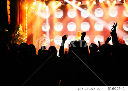 silhouettes of concert crowd in front of bright stage lights silhouettes of concert crowd in front of bright stage lights 61609541