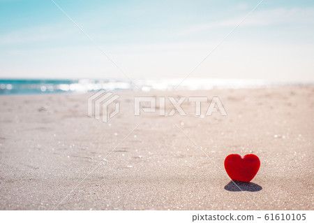 Romantic symbol of red heart on the sand beach 61610105