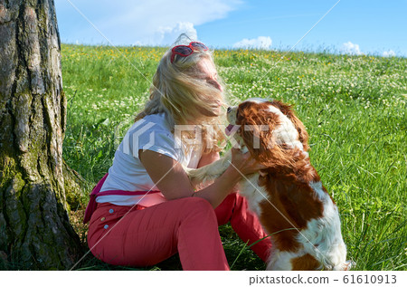Woman cuddling her little dog 61610913