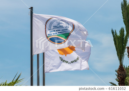 The flag of Agia Napa municipality and the flag of Cyprus. Flags on the flagpole and the stereet lamp post. The wind inflates the flag. The flag of Agia Napa municipality and the flag of Cyprus. Flags on the flagpole and the stereet lamp post. The wind inflates the flag. 61611032