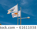 The flag of Agia Napa municipality and the flag of Cyprus. Flags on the flagpole and the stereet lamp post. The wind inflates the flag. 61611038