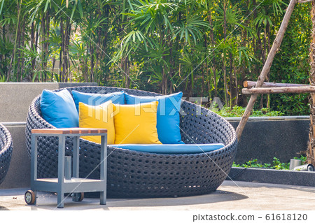 Outdoor patio in the garden with sofa chair and pillow decoration Outdoor patio in the garden with sofa chair and pillow decoration 61618120