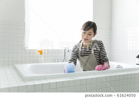 Young woman cleaning the bath Young woman cleaning the bath 61624050