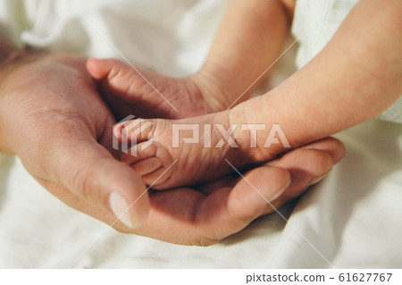 Newborn Baby's feet.Mother holding newborn baby legs,legs massage Newborn Baby's feet.Mother holding newborn baby legs,legs massage 61627767