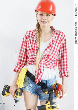Woman wearing helmet using drill 61628603