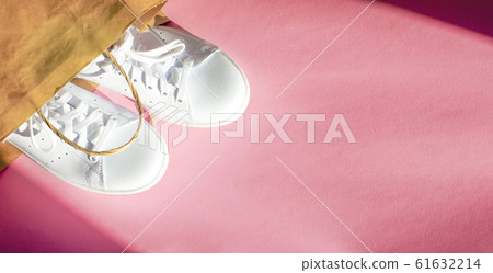 Trendy white sneakers on pink background. Hard 61632214