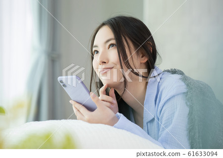 女人睡衣床睡眠醒來的智能手機 61633094