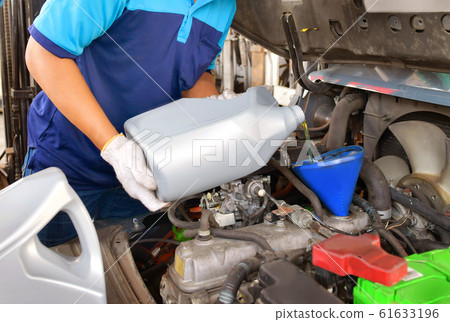 Mechanic adding Engine oil for quality into the engine motor car Transmission and Maintenance Gear.Energy fuel concept. 61633196