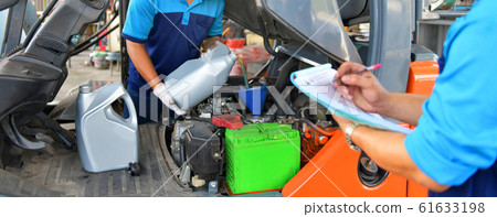 Mechanic adding Engine oil for quality into the engine motor car Transmission and Maintenance Gear.Energy fuel concept. Mechanic adding Engine oil for quality into the engine motor car Transmission and Maintenance Gear.Energy fuel concept. 61633198