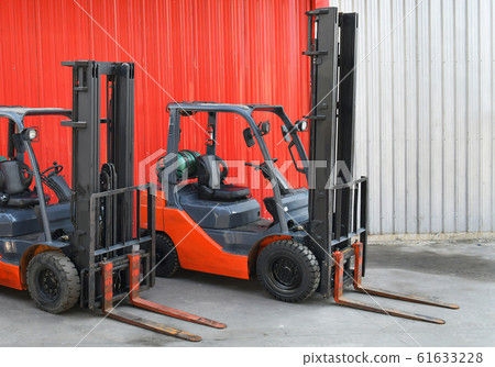 Parked Forklifts in warehouse front 61633228