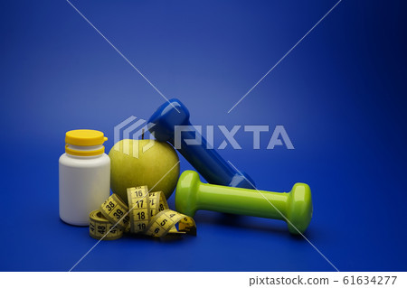 Still life with dumbbells and healthy nutrition Still life with dumbbells and healthy nutrition 61634277