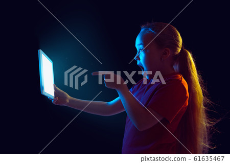 Caucasian girl's portrait isolated on dark studio background in neon light Caucasian girl's portrait isolated on dark studio background in neon light 61635467