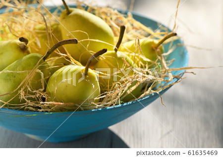 Ripe pears in a basket on wooden table Ripe pears in a basket on wooden table 61635469