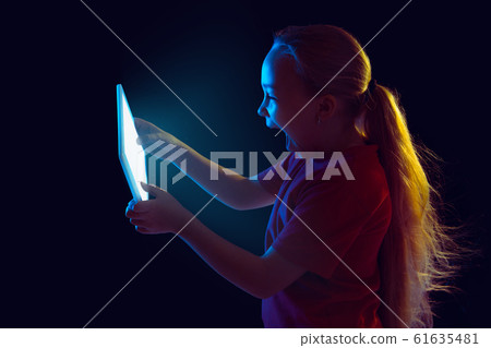 Caucasian girl's portrait isolated on dark studio background in neon light 61635481