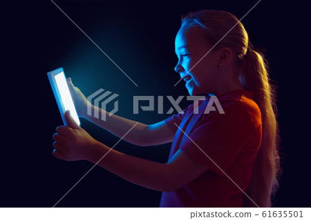 Caucasian girl's portrait isolated on dark studio background in neon light Caucasian girl's portrait isolated on dark studio background in neon light 61635501