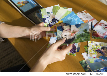 Mother's hand to organize children's photos 61636203