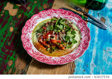 Grilled sirloin with hummus, bacon, cream and plum 61637559