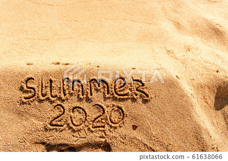Summer 2020 text written on sand on the ocean beach. Travel to the tropics and sea Summer 2020 text written on sand on the ocean beach. Travel to the tropics and sea 61638066