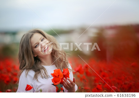 Beautiful happy smiling teen girl portrait with red flowers on head enjoying in poppies field nature background. Makeup and curly hair style. Lifestyle. Beautiful happy smiling teen girl portrait with red flowers on head enjoying in poppies field nature background. Makeup and curly hair style. Lifestyle. 61638196