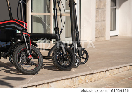 Electric bicycles and scooters on the street.  61639316