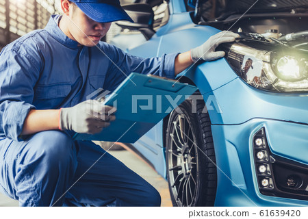 Asian car mechanic technician holding clipboard Asian car mechanic technician holding clipboard 61639420