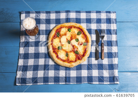 Mozzarella pizza, basil and beer on blue table. 61639705