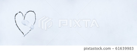 Heart drawn by stick on white snow 61639983