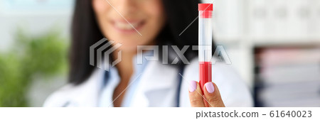 Female doctor hand holding plastic testing tube containing red liquid 61640023