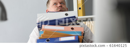 Male businessman carries a bunch of folders and 61640125