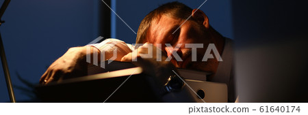 Man sleeping on office table evening time Man sleeping on office table evening time 61640174