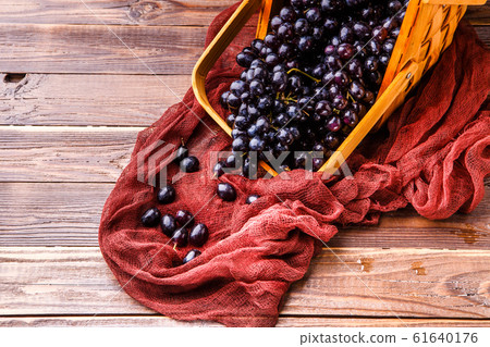 Image from above of black grapes in wooden basket with claret cloth Image from above of black grapes in wooden basket with claret cloth 61640176