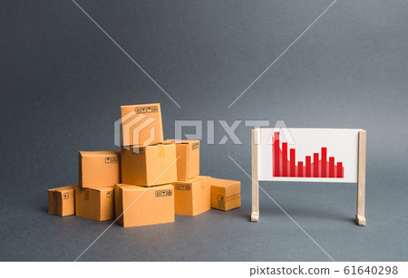 Stack of cardboard boxes and a stand with information chart. rate growth of production of goods and products, increasing economic indicators. exports or imports. Increasing consumer demand 61640298