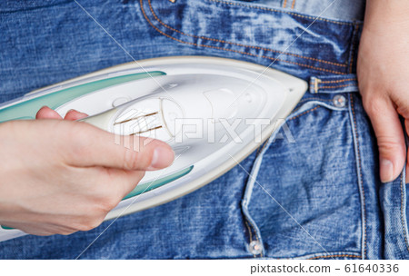 Photo of a man ironing jeans, Photo of a man ironing jeans, 61640336