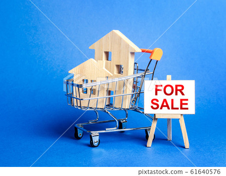 Houses in a shopping cart and an easel sign labeled for sale. Buying and selling real estate, hot offers and property valuation. Smart investments. Discounts and great offers, cheap loans for purchase 61640576