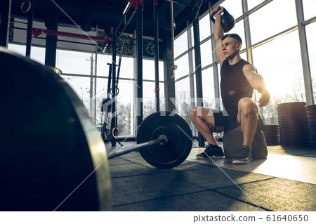 The male athlete training hard in the gym. Fitness and healthy life concept. The male athlete training hard in the gym. Fitness and healthy life concept. 61640650