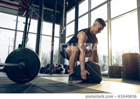 The male athlete training hard in the gym. Fitness and healthy life concept. 61640656