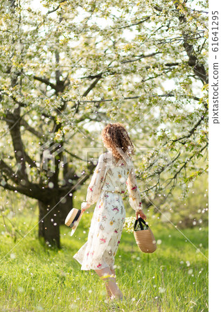 A gorgeous girl walks in a flowering spring A gorgeous girl walks in a flowering spring 61641295