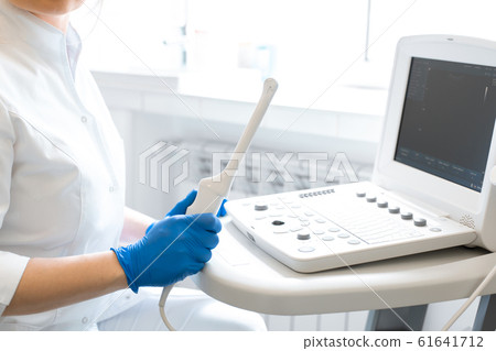 A gynecologist sets up an ultrasound machine. A 61641712