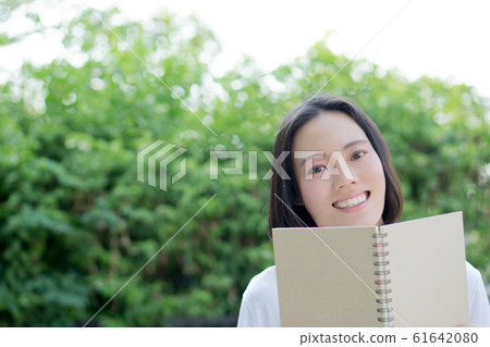 serious young, beautiful girl holding an open 61642080