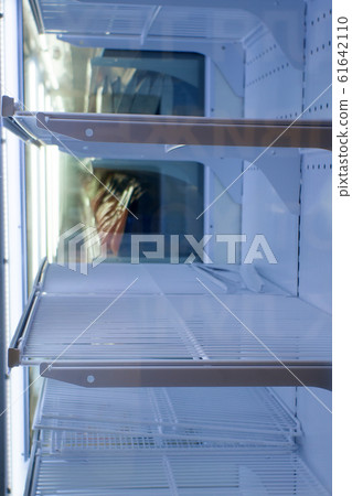 empty refrigerator shelves in the supermarket 61642110