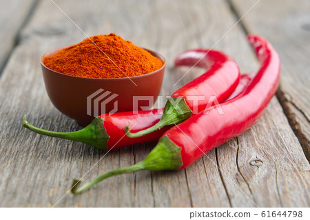 Whole and ground to powder chili pepper on table 61644798